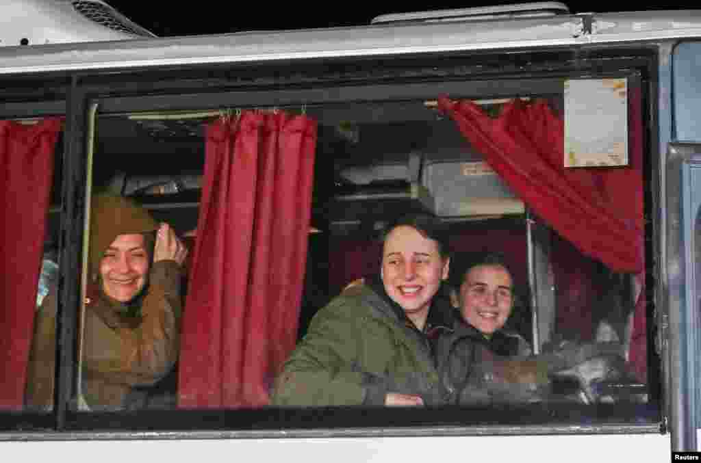 Deținute ucrainene privesc prin geamul unui autobuz când ajung la familiile lor în Zaporojie, pe 16 octombrie 2022, după luni de captivitate în Rusia. 