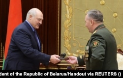 Міністр оборони Білорусі Віктор Хрєнін дарує статуетку копії радянської ядерної бомби фактичному очільнику країни Олександру Лукашенку під час їхньої зустрічі в Мінську, 27 червня 2023 року