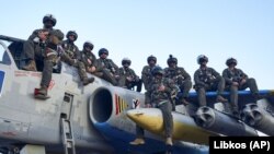 Украински пилоти се сликаат на авион Су-25 од руско производство во база во источна Украина на 4 мај 2023 година