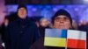 Мужчина слушает выступление президента Украины Владимира Зеленского во дворе Королевского замка в Варшаве. 5 апреля 2023 года