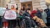 Zeci de asistenți personali și persoane cu nevoi speciale de care au grijă au protestat atât la Ministerul Muncii și Protecției Sociale, cât și la Primăria Chișinău.