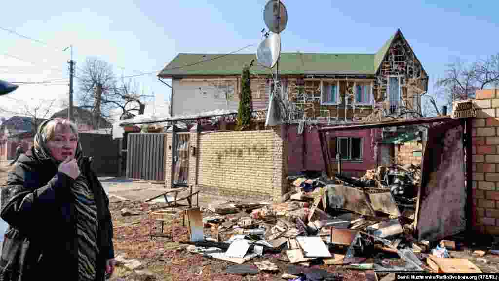 Былая настаўніца Натальля каля свайго разбуранага дома. Наступствы расейскага абстрэлу Шаўчэнкаўскага раёну Кіева, 23 сакавіка 2022 году 