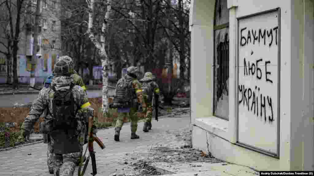 Ukrán katonák egy „Bahmut szereti Ukrajnát” feliratú graffiti mellett december 18-án