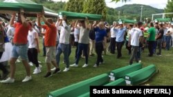 A srebrenicai népirtás ötven áldozatának maradványait tartalmazó koporsókat viszik Potočariban, Bosznia-Hercegovinában 2022. július 10-én