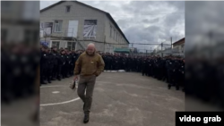 Кадр із відео, в якому особа, схожа на Євгена Пригожина, агітує вʼязнів вступати до лав «ПВК Вагнера»