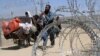 PAKISTAN -- A family arriving from Afghanistan make their way through the Friendship Gate crossing point at the Pakistan-Afghanistan border town of Chaman, Pakistan August 19, 2021