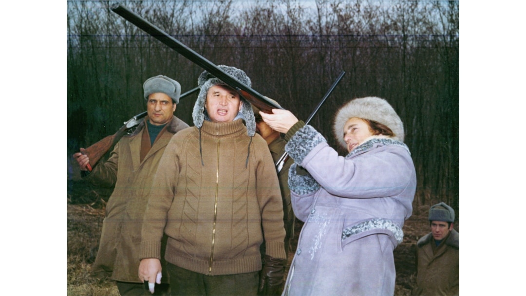 Nicolae Ceausescu, sa zavijenim prstima, gleda suprugu Elenu kako puca iz puške tokom novogodišnjeg lova 1976. godine.