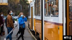 Utasok maszkban szállnak fel egy villamosra Budapesten 2020. október 31-én.