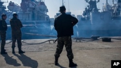Personalul de securitate rusesc din Sevastopol stă de pază în timpul confiscării navelor de război ucrainene după ce Kremlinul a ocupat ilegal Crimeea în 2014.