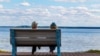 Belarus - Couple in love is resting on a bench by the lake in sunny summer weather. Lake Naroch, undated