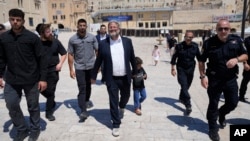 Ministrul Ben Gvir, în centru, flancat de gărzi de corp și polițiști, se îndreaptă dinspre cartierul evreiesc al Ierusalimului vechi spre intrarea în complexul musulman Al-Aqsa, la 13 august 2024.