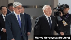 Казакстан президентинин милдетин аткаруучу Касым-Жомарт Токаев (солдо) менен мурдагы президент Нурсултан Назарбаев Нур-Султандагы Астана экономикалык форумуна катышууда. Казакстан, 2019-жыл.
