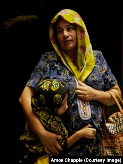 زنی با دخترش از همان باد و باران پناه گرفته است.