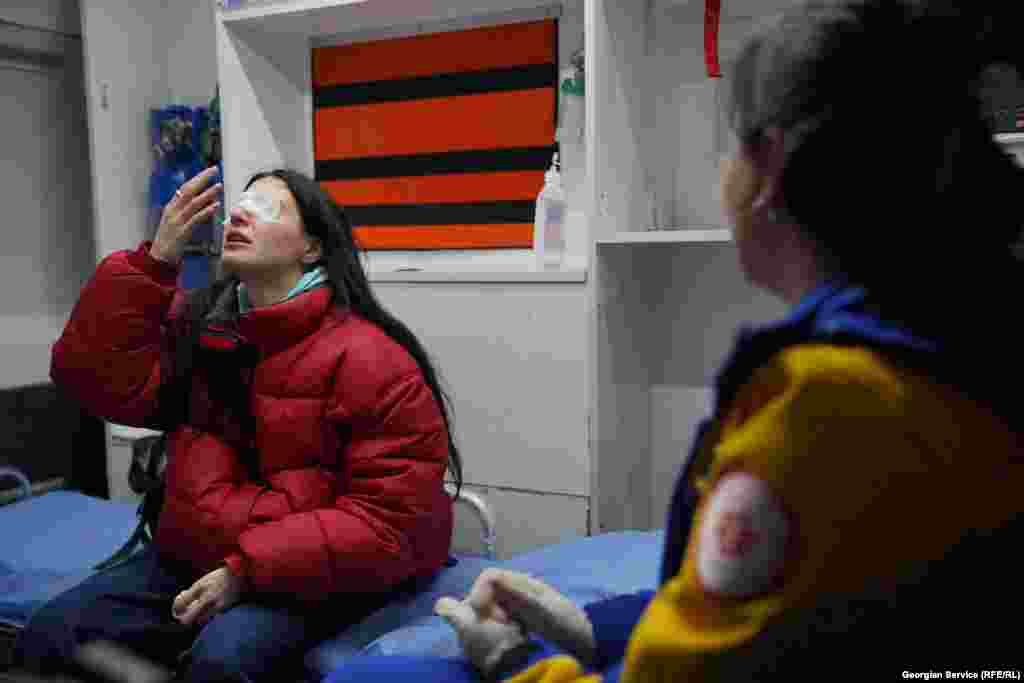 Полициянын көздөн жаш агызуучу газынан жабыркаган демонстрант "Тез жардам" унаасынын ичинде. 