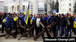 Люди стоять перед військовими Росії під час мітингу проти російської окупації. Херсон, 7 березня 2022 року