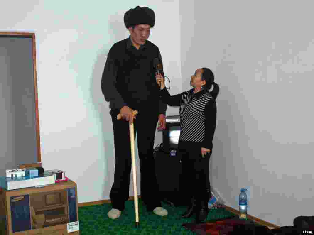 Жаркын Суран кызы өлкөдөгү бою эң узун жигит Жеңишбек Райымбаевге барып, ден соолугун сурап, "Азаттык" үчүн маек куруп жатат. 16-февраль, 2010-жыл. 