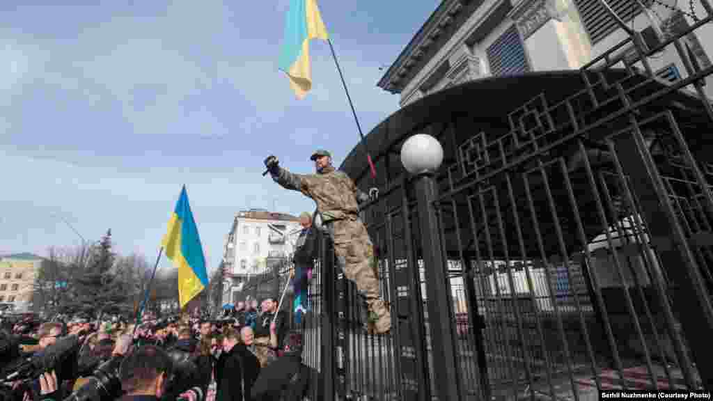 Спочатку агресивно налаштовані активісти закидали будівлю яйцями і зеленкою. Пізніше двоє молодиків перебралися через паркан